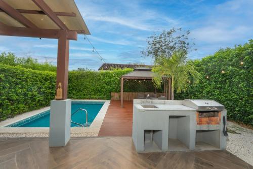 a backyard with a kitchen and a swimming pool at Playa Tamarindo, CasaMar de Tamarindo in Tamarindo