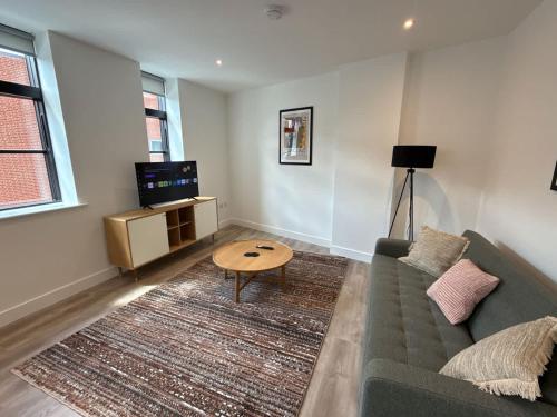 a living room with a couch and a table at Beautiful 1 bed - 5 Queen Street Abingdon - Centrally located parking subject to availability - Ashbrook Serviced Apartments in Abingdon