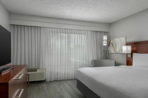 a hotel room with a bed and a window at Courtyard by Marriott Houston Rice University in Houston