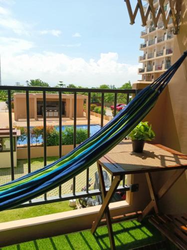 a hammock on a balcony with a view of a pool at Homey Apartment with Olympic-sized pools in Lapu Lapu City