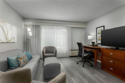 a living room with a couch and a desk with a computer at Courtyard by Marriott Houston Rice University in Houston