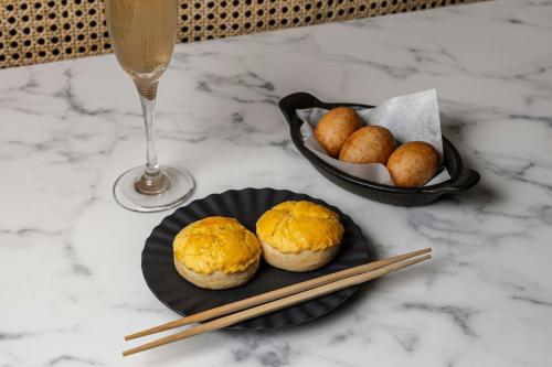 a table with a plate of biscuits and a glass of wine at Courtyard by Marriott Houston Rice University in Houston