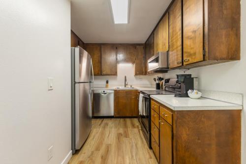 a kitchen with wooden cabinets and a stainless steel refrigerator at Comfortable Townhouse in Ash Way Lynnwood in Lynnwood