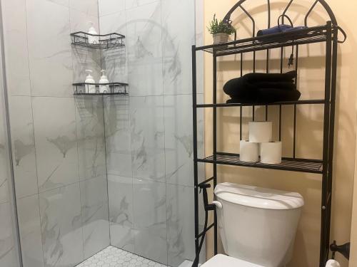 a bathroom with a shower with a toilet and towels at The Grassy Oasis in Brampton