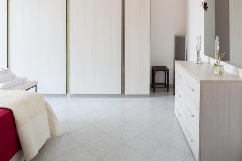 a white bedroom with a bed and a dresser at Bed & Breakfast Cozy Hills in Cagli