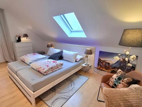 a bedroom with a bed and a skylight at Apartment Chalet am Schloss Kaltenberg nahe Ammersee in Geltendorf