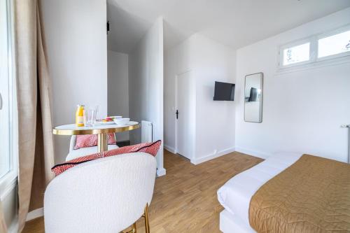 Cette chambre comprend un lit, une table, une table et une chaise. dans l'établissement Studio Banlieue Parisienne Issy-les-Moulineaux-III, à Issy-les-Moulineaux