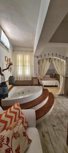 a large room with a tub and a bedroom at Mon Ilıca Otel in Çeşme