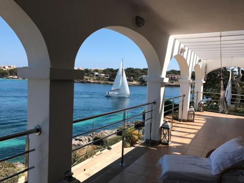 a sailboat on the water from a house balcony at Casa Vora Mar in Felanitx
