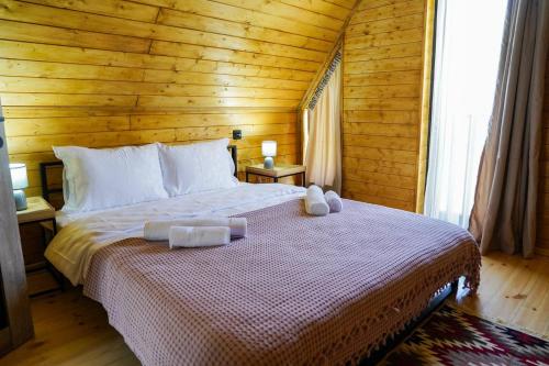 a bedroom with a bed with two towels on it at Tuta Area Cottage in Kazbegi
