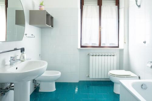 a white bathroom with a sink and a toilet at Bed & Breakfast Cozy Hills in Cagli