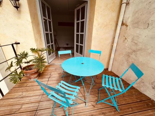 une table bleue et des chaises sur une terrasse en bois dans l'établissement Appartement avec terrasse dans une cour privée, à Avignon