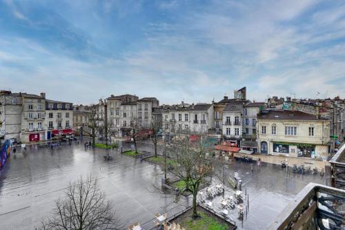 une ville humide avec des bâtiments et des gens dans une rue dans l'établissement Appartement très charmant à Bordeaux, à Bordeaux