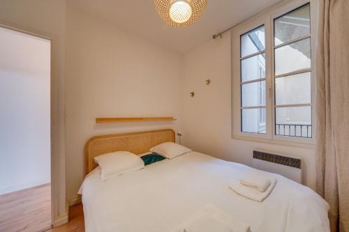 une chambre avec un lit blanc et une fenêtre dans l'établissement Appartement très charmant à Bordeaux, à Bordeaux