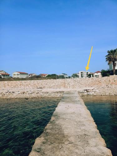a pathway leading into the water next to a beach at Seaside Serenity "Earth" with pool, 150m from sea in Sukošan