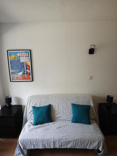 - un salon avec un canapé et 2 oreillers bleus dans l'établissement Studio Léo, à Calvi
