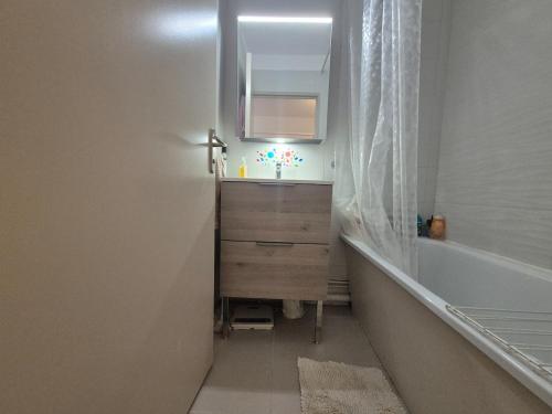 une salle de bain avec un lavabo, un miroir et une baignoire dans l'établissement Appartement T2 La Baie des Anges, à La Ciotat