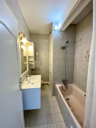 une salle de bain avec un lavabo et une baignoire dans l'établissement Nice West Pretty one bedroom, à Nice