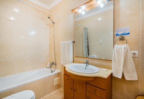 a bathroom with a sink and a toilet and a tub at Pool&Beach in Encosta de São José in Albufeira