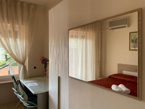 a mirror in a room with a bed and a desk at Oasi Venus Perugia e Assisi in Ponte San Giovanni