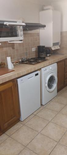 une cuisine avec un lave-linge et un lave-linge dans l'établissement Villa en pierre de taille, à La Celle-sous-Gouzon