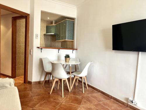 a dining room with a table and white chairs at Apartamento Bellavista Close to the airport in Torremolinos