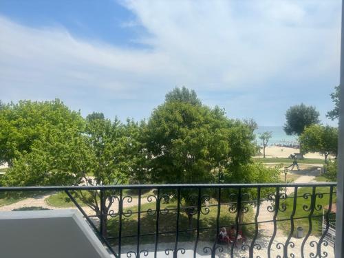 a balcony with a view of the beach and trees at Indigo sea view rooms in Olympiaki Akti