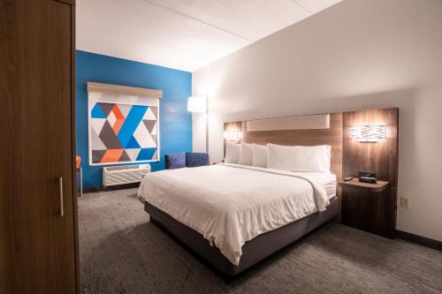 a bedroom with a large bed and a blue wall at Holiday Inn Express Hotel & Suites Orange City - Deltona by IHG in Orange City