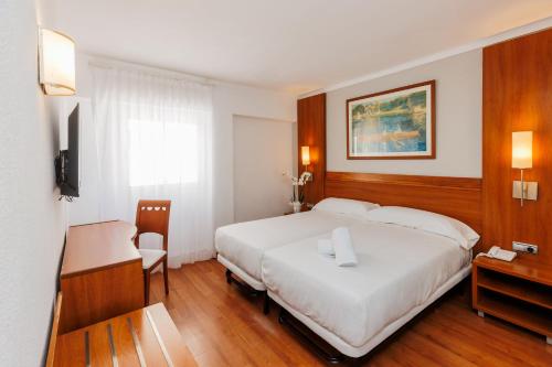 a bedroom with a large white bed and a desk at O7 Colombo in S'Illot