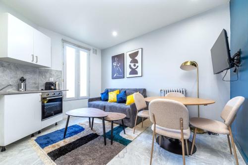 un salon avec une table et un canapé bleu dans l'établissement Appartement Gagny centre proche RER - III, à Gagny