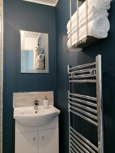 a bathroom with a sink and a mirror at Entire Spacious 3-Bed Family Home, City Centre, Free Parking, Garden in Glasgow