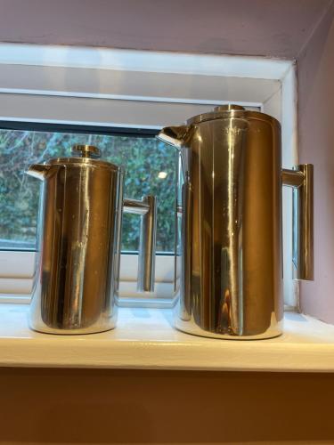 two metal kettles sitting on a window sill at Luxury flat in Totnes in Totnes