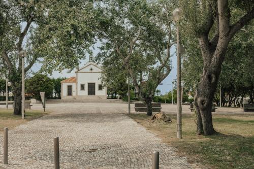 a building in the middle of a park with trees at Torreira Beach Apartment in Torreira