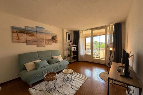 un salon avec un canapé vert et une télévision dans l'établissement Studio with pool close to the beach, à Fréjus