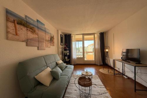 un salon avec un canapé et une télévision dans l'établissement Studio with pool close to the beach, à Fréjus