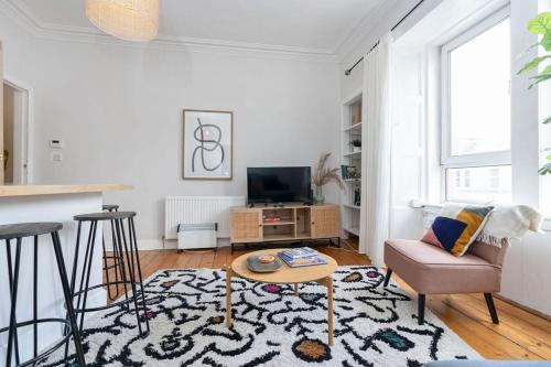 a living room with a couch and a tv at GuestReady - Modern 1BR in Edinburgh in Edinburgh