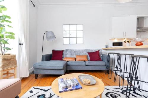 a living room with a blue couch and a table at GuestReady - Modern 1BR in Edinburgh in Edinburgh