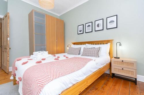 a bedroom with a bed with a red and white blanket at GuestReady - Modern 1BR in Edinburgh in Edinburgh