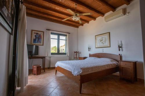 ein Schlafzimmer mit einem Bett und einem Deckenventilator in der Unterkunft Luxurious Sea Side 3 Bedroom House Aegina Island in Vathí