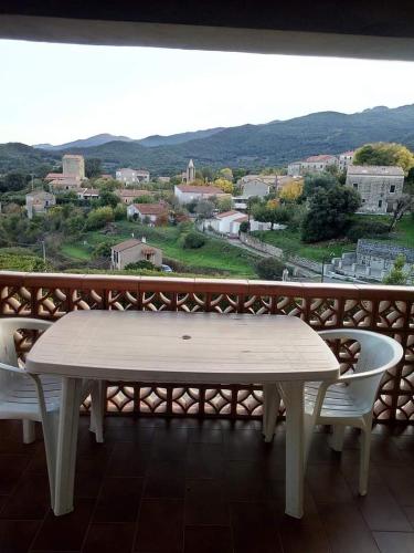 une table et deux chaises sur un balcon avec vue dans l'établissement Villa en pierre de taille, à La Celle-sous-Gouzon