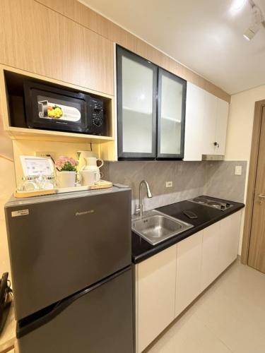 a small kitchen with a sink and a microwave at Mall of Asia Casa de Lune at Shore 2 in Manila