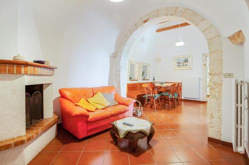 a living room with a red couch and a fireplace at GuestHost - Trulli La Ghianda in Noci