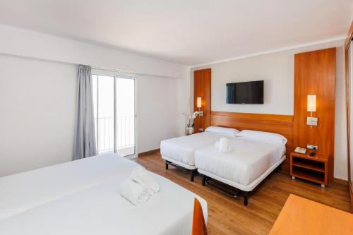 a hotel room with two beds and a tv at O7 Colombo in S'Illot