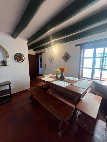 a dining room with a table with flowers on it at La Morada de la Villa 101 in Villa de Leyva