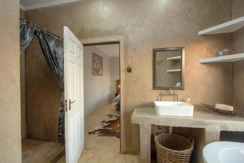 a bathroom with a sink and a mirror at Doornkom in Marloth Park