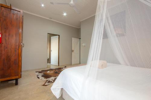 a bedroom with a bed with a mosquito net at Doornkom in Marloth Park