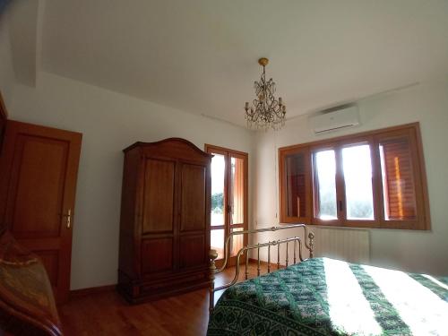 a bedroom with a bed and a chandelier at Carachouse Pellaro in Pellaro