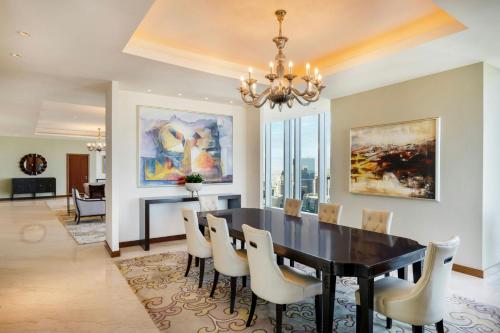 a dining room with a black table and white chairs at JW Marriott Marquis City Center Doha in Doha