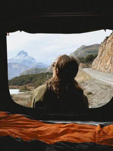 a woman sitting in a tent looking out of a window at Camper camioneta equipada cajon del maipo in San José de Maipo