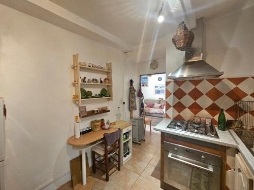 - une cuisine avec une table et un comptoir dans l'établissement Jolie maison de village- Cap Corse Pietracorbara, à Pietracorbara